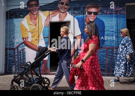 Shoppers and Advertising on the Kings Road, am 20. Mai 2025 in London, England. Stockfoto