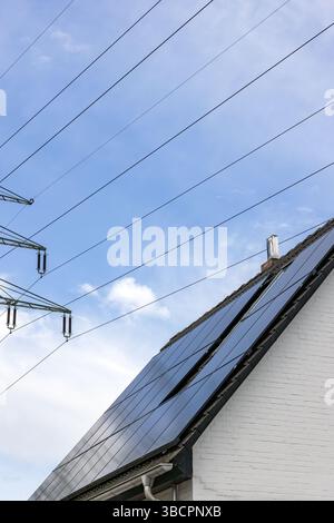 Einfamilienhaus mit Sonnendach unter Hochspannungsleitung Stockfoto