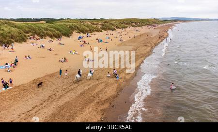 Aus der Vogelperspektive auf Irvine Beach an einem Sommertag, bei dem Familien und Besucher die sandige Küste von Ayrshire im Südwesten Schottlands genießen Stockfoto