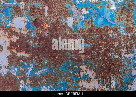 Nahaufnahme einer korrodierten Metalloberfläche mit blauer abblätternder Farbe und starkem Rost für einen grungy industriellen Hintergrund. Stockfoto
