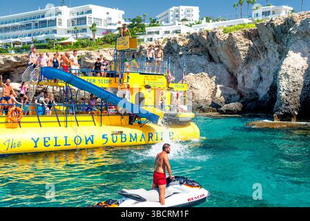 Ayia Napa, Zypern - 10. August 2019: Gelbes U-Boot-Vergnügungsboot mit Touristen Stockfoto
