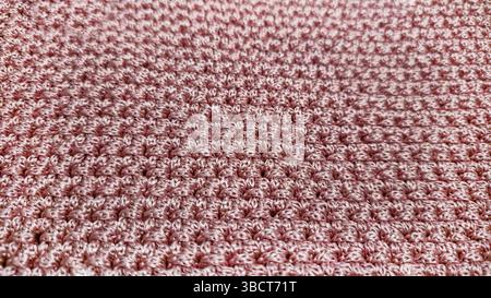 Stricken von Elementen einer rosafarbenen Damentasche, Handstricken mit langem Griff. Schritt-für-Schritt-Anweisungen. Auf grauem Hintergrund. Stockfoto