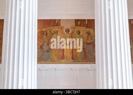WASHINGTON DC – das „Unity“-Wandgemälde von Jules Guerin ziert die Nordkammer des Lincoln Memorial über der zweiten Inschrift der Antrittsrede. Dieses in den 1920er Jahren entstandene, 60 m x 12 Fuß große allegorische Gemälde zeigt den Engel der Wahrheit, der die Hände von Figuren verbindet, die den Norden und den Süden repräsentieren, wobei ihre Flügel Darstellungen von sieben Künsten, darunter Malerei, Philosophie und Architektur, schützen. Das Wandgemälde zeigt den Architekten Henry Bacon als vierte Figur links vom Engel, mit Gruppen, die auf beiden Seiten Fraternity und Charity vor einem Hintergrund von Zypressen symbolisieren. Stockfoto
