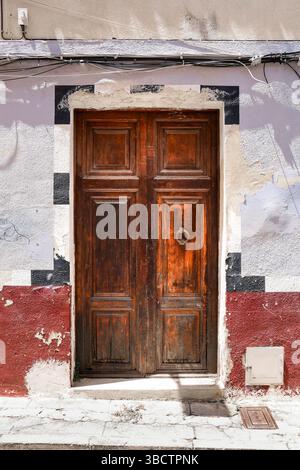 Alte Holztür mit abgebrochener Fassade in der Altstadt von Denia, Spanien Stockfoto