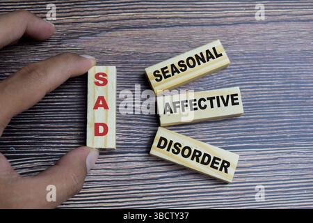 Das Konzept von SAD - Symbol der saisonalen affektiven Störung. Holzblock mit den Worten TRAURIG - saisonale affektive Störung Stockfoto