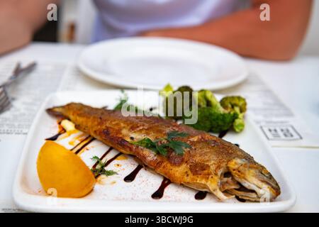 Braten der Forelle mit Zitrone und Brokkoli im Restaurant Stockfoto