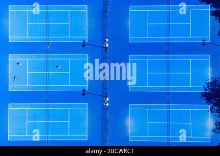 Vier Personen, die in der Sommersonne auf den Tennisplätzen im Wythenshawe Park in der Nähe von Manchester am 21. Mai 2025 gespielt haben. Stockfoto