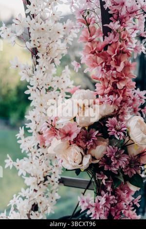 Eleganter künstlicher Blumenstrauß mit zartem rosafarbenem weiß und rötlichen Pfingstrosen, Chrysanthemen und Gartenblüten in einer romantischen Frühlingskomposition für Stockfoto