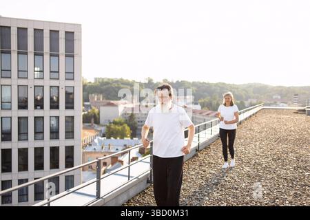 Seniorenpaar, das im Freien auf dem städtischen Dach für Gesundheit und Wellness trainiert Stockfoto