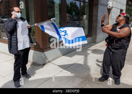 Portland, USA. Mai 2025. Ein Demonstrant konfrontiert einen Mann, der eine israelische Flagge hält. Etwa 75 Menschen demonstrierten am 21. Mai 2025 im ICE-Hauptquartier (Immigration and Customs Enforcement) in Portland, Oregon, um gegen die Massendeportationen des Trump-Regimes zu protestieren. (Foto: John Rudoff/SIPA USA) Credit: SIPA USA/Alamy Live News Stockfoto