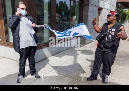 Portland, USA. Mai 2025. Ein Demonstrant konfrontiert einen Mann, der eine israelische Flagge hält. Etwa 75 Menschen demonstrierten am 21. Mai 2025 im ICE-Hauptquartier (Immigration and Customs Enforcement) in Portland, Oregon, um gegen die Massendeportationen des Trump-Regimes zu protestieren. (Foto: John Rudoff/SIPA USA) Credit: SIPA USA/Alamy Live News Stockfoto