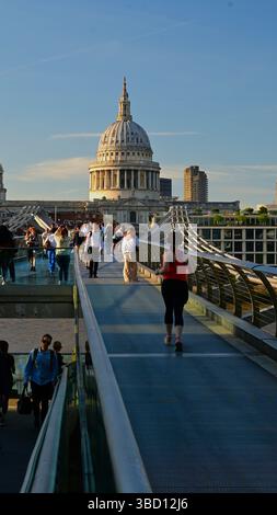 Auf der Millennium Bridge über die Themse mit Blick auf die St. Paul's Cathedral mit vielen Menschen im Blick. Stockfoto