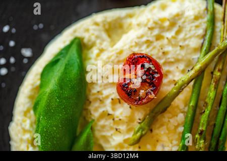 Omelett mit gebackenem Spargel, Tomaten und Basilikum. Nahaufnahme, Hintergrund. Zur Verwendung in Menüs und Bannern. Das Konzept eines leckeren und gesunden Frühstücks. Stockfoto