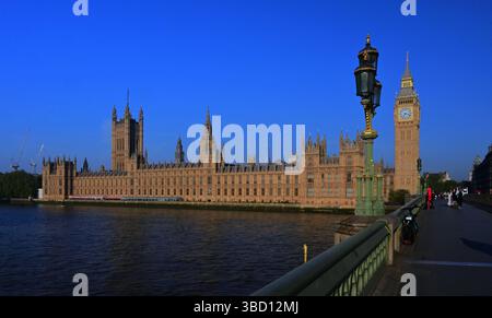 Houses of Parliament und Big Ben am frühen Morgen auf der Westminster Bridge mit blauem Himmel, wenige Menschen ohne Verkehr Stockfoto