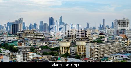 Weitwinkel-Panoramablick auf Bangkok, Thailand, mit einem beeindruckenden Kontrast zwischen verfallenen Gebäuden aus der Mitte des Jahrhunderts und modernen Hochhäusern in Th Stockfoto
