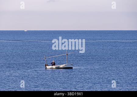 Fischer in einem kleinen Boot, das im Meer fischt Stockfoto