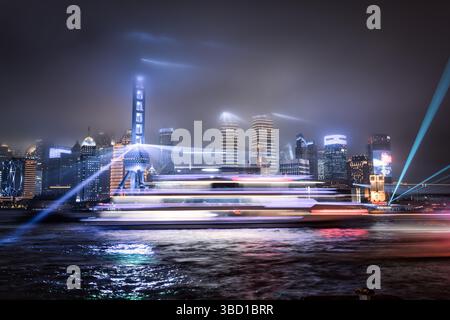 Lasershow über der beleuchteten Lujiazui Skyline und dem Huangpu Fluss bei Nacht, Shanghai, China Stockfoto