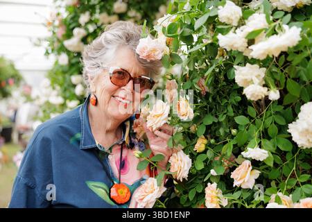 PRU Leith, Great British Bake Off Moderator, der Rosen am Peter Beales Roses Ausstellungsstand auf der Chelsea Flower Show 2025 riecht. Stockfoto