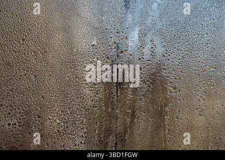 Feuchter Glashintergrund, Kondensation bildet empfindliche Wasserperlen auf gekühlter Glasinnenoberfläche. Winzige Tropfen sammeln sich zu wachsenden Perlen vor gravit Stockfoto