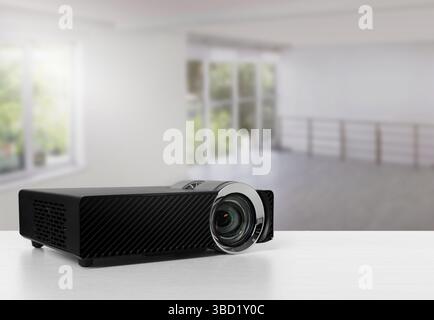 Moderner Videoprojektor auf weißem Tisch im Zimmer Stockfoto