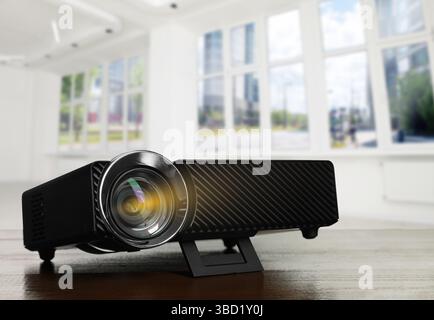 Moderner Videoprojektor auf Holztisch im Zimmer Stockfoto