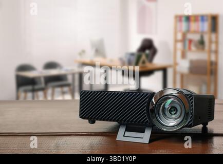 Moderner Videoprojektor auf Holztisch im Büro Stockfoto