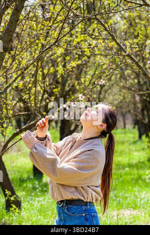 Stellen Sie sich einen Blick auf den Mandelgarten vor, während ein sehr schönes und attraktives Mädchen im Busen der Natur spaziert und die Schönheit unseres Planeten bewundert. Das ist sie Stockfoto