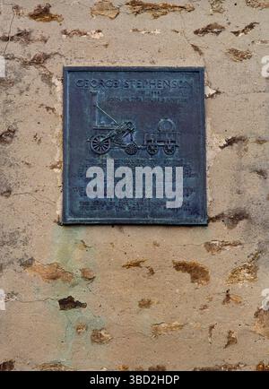 Gedenktafel aus Metall an der Wand des Geburtsortes des 18. Eisenbahnpioniers George Stephenson in Wylam, Northumberland, England, Großbritannien Stockfoto