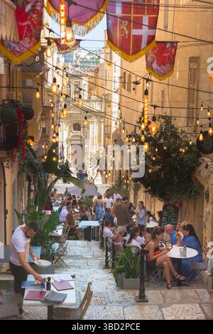 Valletta Café, Blick im Sommer auf eine beliebte Straße mit Cafés und Restaurants im historischen Zentrum der Stadt Valletta, Malta Stockfoto