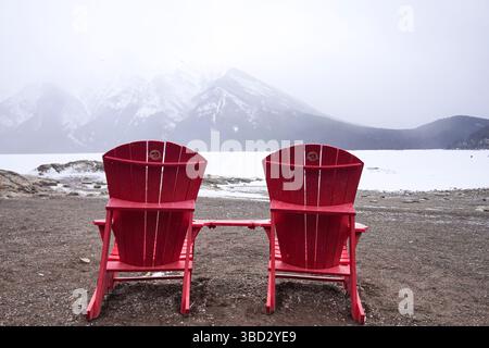 Red Adirondack Parks Canada Stühle am Lake Minnewanka im Winter Stockfoto