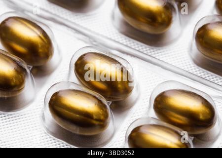 Goldene Gelkapseln in Blisterpackung. Nahaufnahme der Nahrungsergänzungspackung. Omega-3-Fischöl-Pillen. Pharmazeutisches Gesundheitsprodukt. Vitamin Wellness. Stockfoto