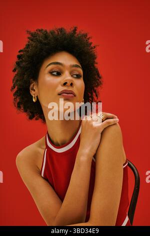 Eine wunderschöne junge Frau mit natürlichen Locken zeigt ihren Sinn für Mode und einzigartigen Stil. Stockfoto