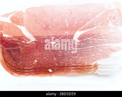 Ein Stück Fleisch mit rosafarbener Farbe. Sie wird in Scheiben geschnitten und auf einem weißen Hintergrund platziert Stockfoto