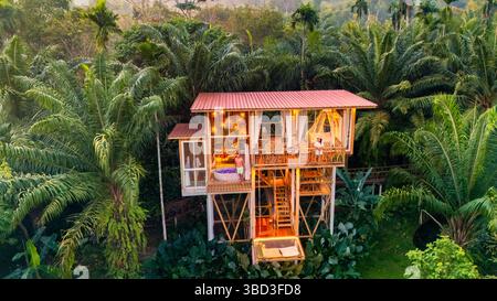 Dieses charmante Baumhaus bietet eine warme und einladende Umgebung, umgeben von lebhaftem Grün. Es bietet einen perfekten Kurzurlaub für Entspannung bei Sonnenaufgang im zauberhaften Dschungel-Regenwald. Stockfoto