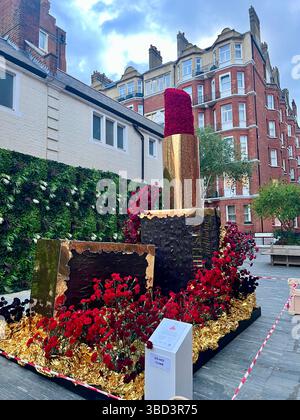 Chelsea in Bloom 2025, aufwendige Blumendekoration in Form eines Lippenstiftetui und rotem Lippenstift. Aufgenommen in Chelsea, London. Keine Personen Stockfoto