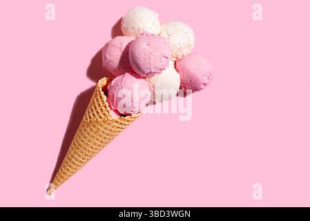 Eisbecher mit Erdbeeren- und Vanillekugeln auf rosa Pastellhintergrund, kreative flache Lay, Kopierraum. Viele leckere Bio-Eissorten werden eingelegt Stockfoto