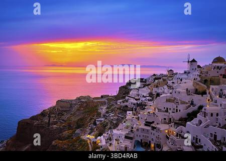 Wunderschöner Blick auf das Dorf Oia mit traditionellen weiß getünchten Häusern und Windmühlen, Insel Santorin, bei Sonnenuntergang, Griechenland. Landschaftlich reizvoller Reisehintergrund, berühmt Stockfoto