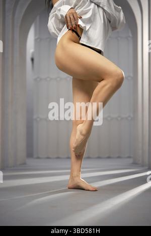 Unerkennbare barfuß Frau beugte ihr hochgezogenes Bein am Knie Stockfoto