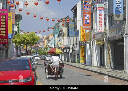 Fahrrad-Rikscha, beca mit Schirm durch die Einkaufsstraße in der Stadt George Town, Georgetown, Penang, Malaysia Stockfoto