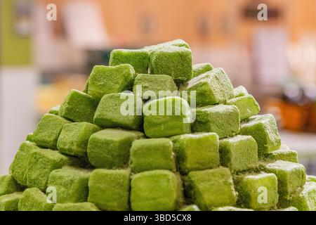 Nahaufnahme eines Stapels von Matcha Green Tea Mochi, einem trendigen japanischen Dessert, das auf dem Nishiki Food Market verkauft wird. Absichtlicher selektiver Fokus. Stockfoto