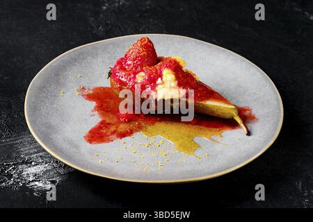 Teller mit süß gebackenen Birnen mit Mascarpone, Karamellsirup und Erdbeermarmelade Stockfoto