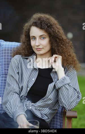 Außenporträt einer süßen jungen Frau mit langen Locken Stockfoto