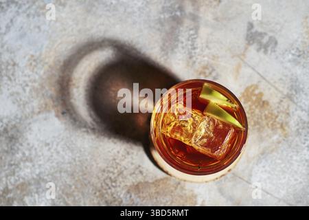 Blick von oben auf den Apfelsaft-Whiskey-Cocktail unter hartem Sonnenlicht Stockfoto