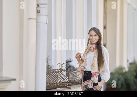 Sunny Lifestyle-Porträt einer jungen, stilvollen Frau, die auf der Straße geht, in trendigem Outfit Stockfoto