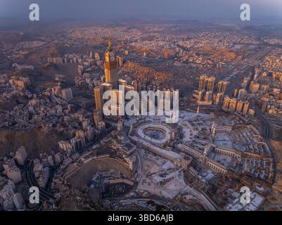Blick aus der Vogelperspektive auf die große Moschee mit der Kaaba, der heiligsten Stätte des Islam, und dem Abraj Al-Bait Uhrturm, beleuchtet von der frühen Morgensonne im h Stockfoto