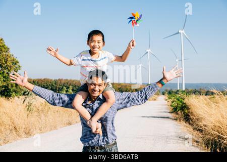 Vater hält Tochter mit Windrad Stockfoto