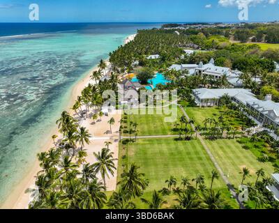 Weite Sicht aus der Vogelperspektive auf die lebhafte türkisfarbene Küste mit Korallenriffformationen und flachem Wasser in Flic en FLAC, Mauritius Stockfoto