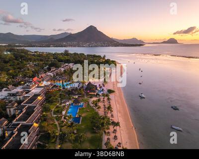 Ein traumhaftes, von Palmen gesäumtes Resort in der Dämmerung, eingebettet am Strand im wunderschönen Le Morne, Mauritius Stockfoto