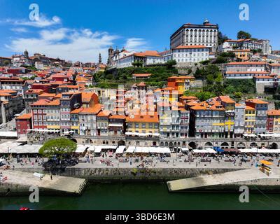Porto, Portugal - 12. Mai 2024: Ribeiras Flussufer mit bunten Häusern und Touristen am Kai Stockfoto