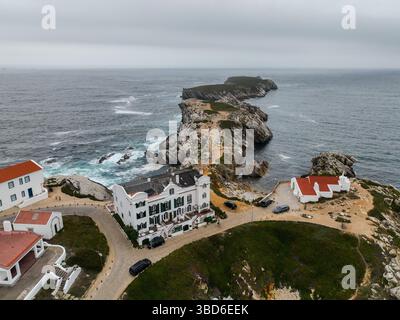 Blick von oben auf weiße Gebäude und Fußweg, der über Klippen zur Insel führt Stockfoto